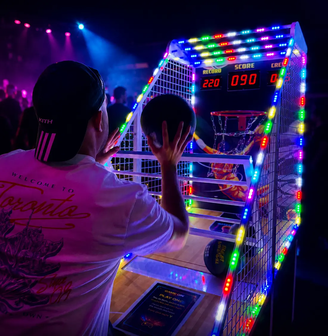 Player shooting on the Power Hoops basketball machine under venue lighting