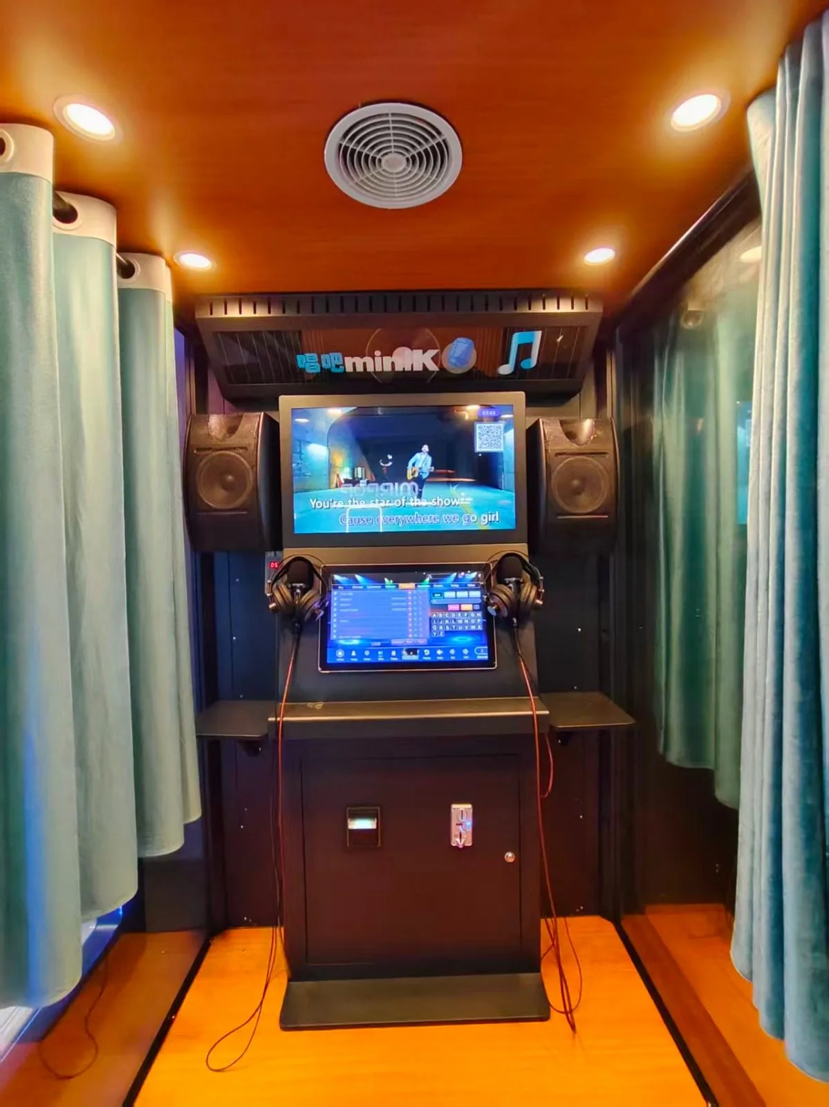 Inside the Music Bar karaoke booth: screens, speakers and curtains