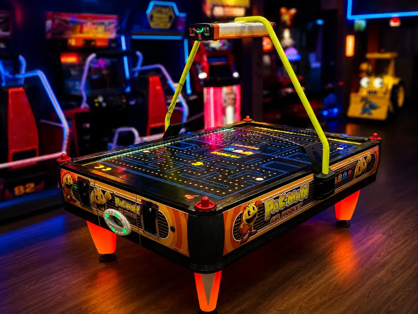 Pac-Man Air Hockey cabinet in orange and black with electronic scoreboard