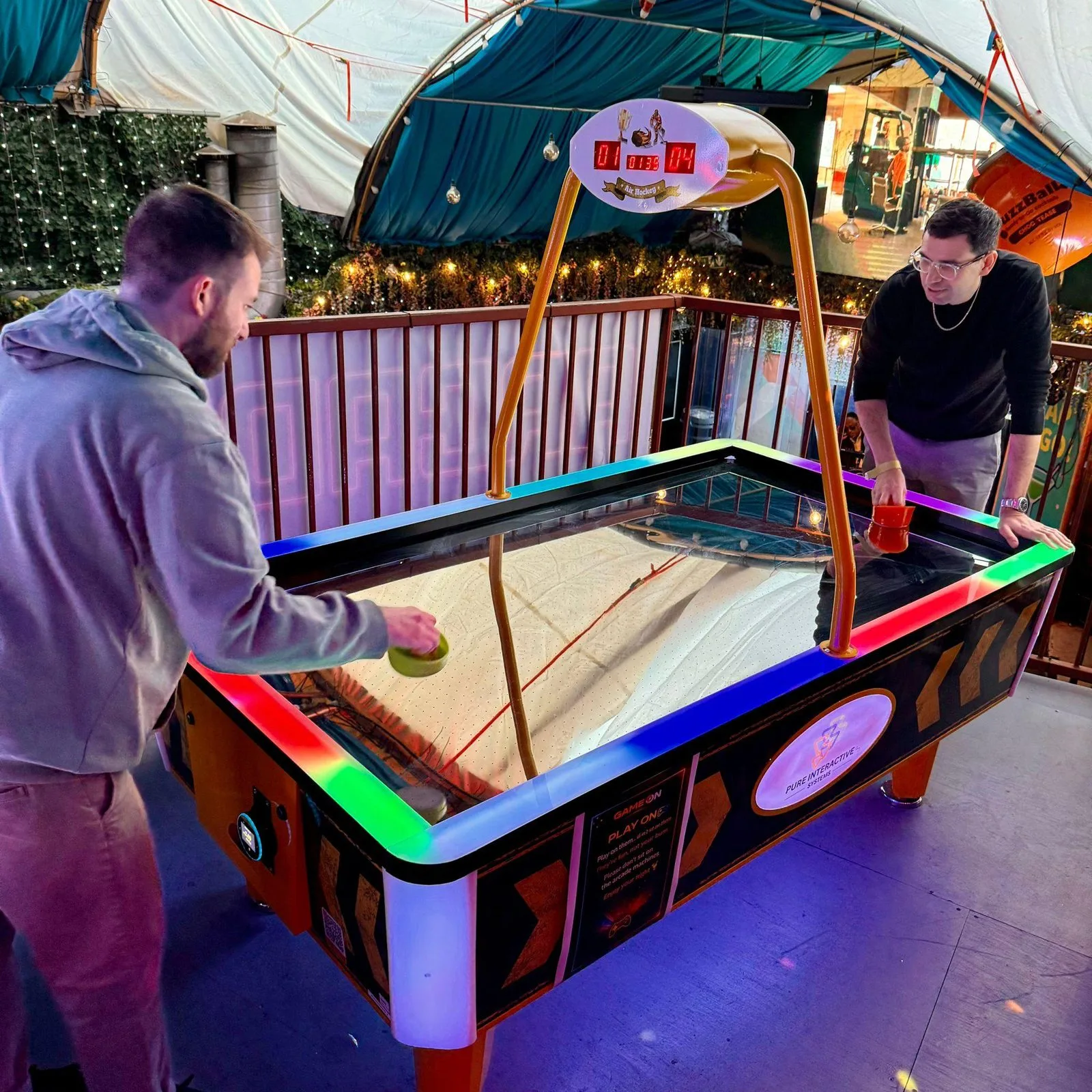 Two players on the Power Glide LED air hockey at Fire London, Vauxhall