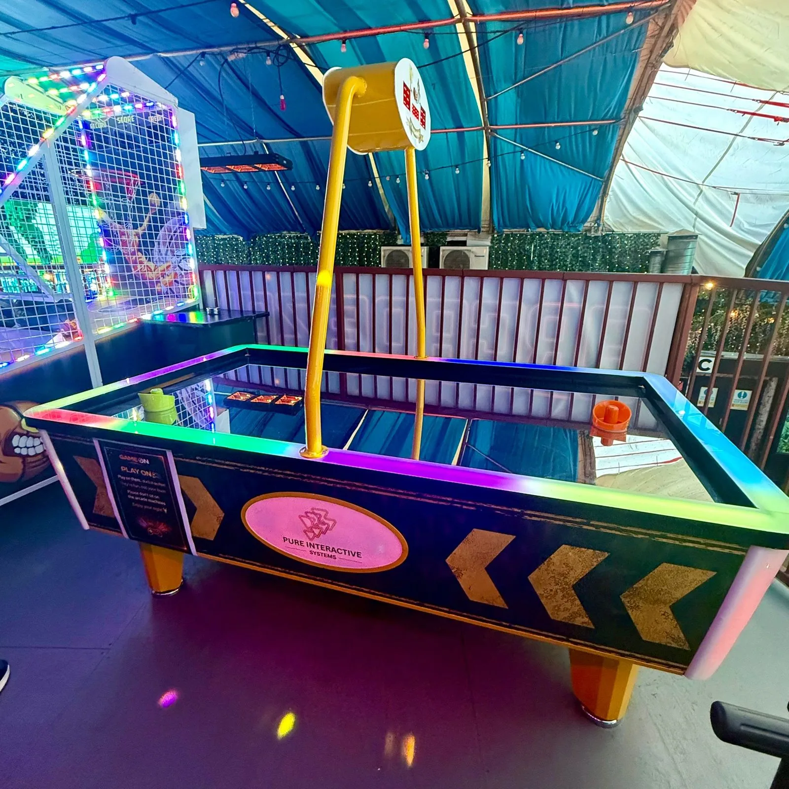 Power Glide air hockey table with yellow arch scoreboard and Pure Interactive Systems branding