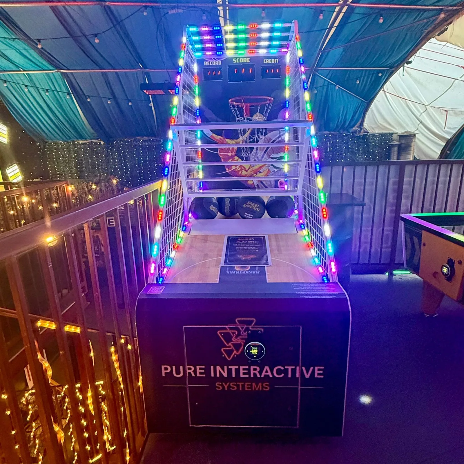 Power Hoops basketball machine front-on with Pure Interactive Systems logo and balls in the chute